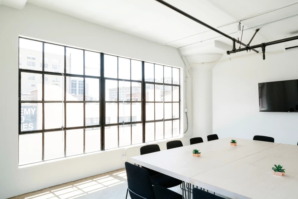 Bright empty office meeting room with a long table and large windows